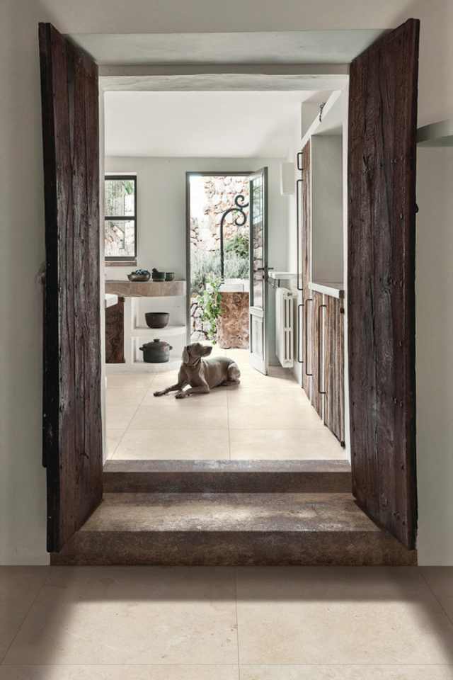 ivory color limestone tile in southwest style entryway with wooden doors